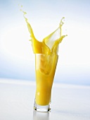 Pouring orange juice into a glass (splash)