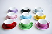 Coloured coffee cups and saucers in rows