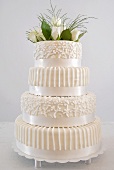 Four-tiered white wedding cake with floral decoration