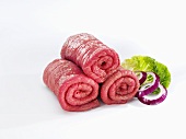 Raw beef for roulades with onion rings and lettuce leaf