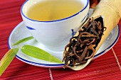 Uncaria-Zweige und Dornen mit einer Tasse Tee