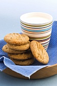 Peanut biscuits, stacked, with beaker of milk