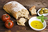 Stillleben mit Ciabatta, Olivenöl, Oliven und Tomaten