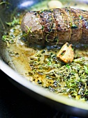 Fried pork fillet with cress in frying pan (detail)