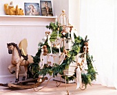 Wired frame of Christmas tree with decoration and teddy bear besides rocking horse