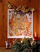 Adventskalender mit Stadtmotiv hängt an der Wand, Adventskranz