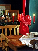 Hängender Kerzenleuchter mit roter Schleife über Esstisch