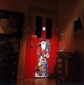 Übergroße Weihnachtsmann-Figur an roter Tür