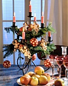 Christmas decoration with angel figurines, lit candles and red baubles on candle stand