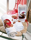 Zusammengerollte Handtücher mit weihnachtlichen Teddybären