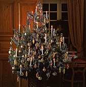 Weihnachtsbaum mit blauen Schleifen und buntem Glasschmuck