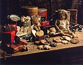 Puppe und Keksdosen auf einem Holztisch nostalgisch arrangiert