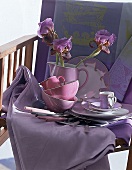 Lila Geschirr mit Blüten auf Tischdecke