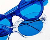 Close-up of two sunglasses with blue tinted lenses