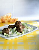 Meatball with dill yogurt and cucumber on white plate