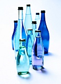 Different sizes of bottles in shades of blue on white background