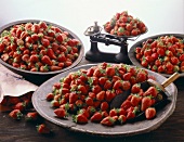 Vier verschieden große Schalen voller Erdbeeren