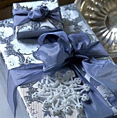 Päckchen in silbernem Gechenkpapier mit blauer Schleife