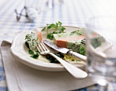 Yogurt terrine with herbs and pesto on white plate with fork and knife