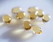 Close-up of vitamin E capsules on white background