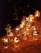 Brennende Windlichter dekoriert mit Olivenzweigen