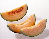 Close-up of three slices of cantaloupe melons on white background