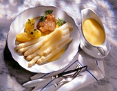 Asparagus with meat, potatoes and hollandaise sauce in serving dish