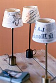 Close-up of decoupage lampshades made from newspaper, map and sheet music