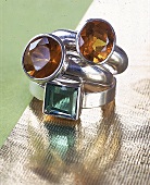 Zwei Silberringe: je mit einem grünen und honigfarbenen Glasstein