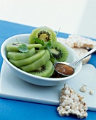 Bowl of kiwi with honey and crunchy rice on side