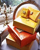 Geschenke in gelben+orangefarb. Lackpapier+dünner Kordel