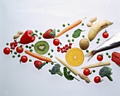 Diverse Gemüse, Früchte und ein Fisch, pfeilförmig angeordnet