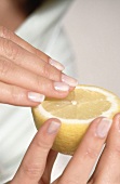 Fingernägel werden in eine Zitrone gepreßt