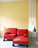 Zwei rote Sesselbetten vor gelber Wand