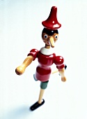 Close-up of wooden figure of Pinocchio against white background