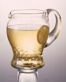 Glaskaraffe gefüllt mit Apfelschorle Scheibe Zitrone -Freisteller-