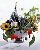 Edelstahlterrine als Champagnerkühler mit Flasche, Gläsern, Blumen