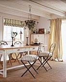 Eßzimmer mit rustikalem Holztisch und filigranen Eisenstühlen