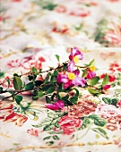 Camellia with red flower lying on towel with flower print