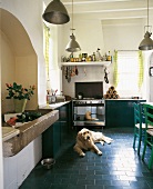 Küche: Blaue Fußbodenfließen, Alkove mit altem Steinwaschbecken
