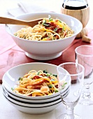 Two bowls of linguine with roasted red pepper and oregano