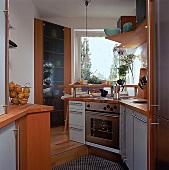 Kleine Küche: Dreiecksschrank, grüne Glasschüsseln auf dem Regal