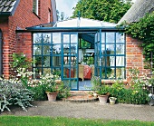 Wintergarten mit Wand und Dach aus Glas, zwischen zwei Häusern