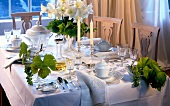 elegante Festtafel mit weißem Porzellan, Kristall u. Silber