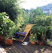 Kleine Terrasse mit Bambusliegestuhl Bambus, Hanfpalme, Schnuchlilie.