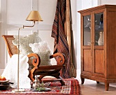 Sessel aus Rohrgeflecht, abgesteppte Baumwollkissen + Decken