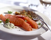 Marinated salmon, zucchini rosti with basil cream on plate