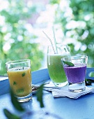 3 Gläser mit Joghurt-Shakes: Heidelbeere, Melone und Pfirsich