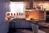 Blaue Küche mit heller Holzoberfläche, niedriges Kochfeld
