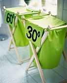 Close-up of two wooden drying rack with green laundry bags and temperature imprint
